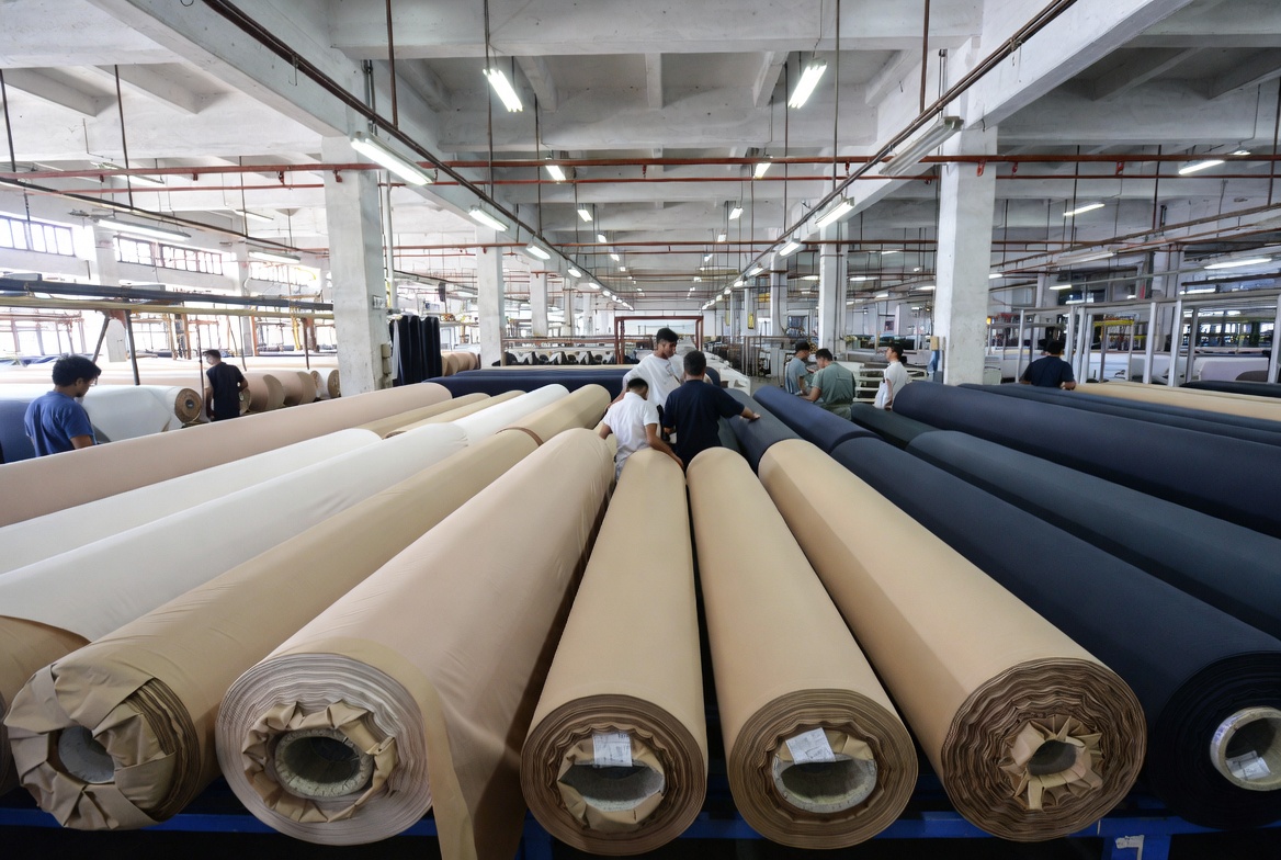 Factory Workers Inspecting Wool Fabric Rolls
